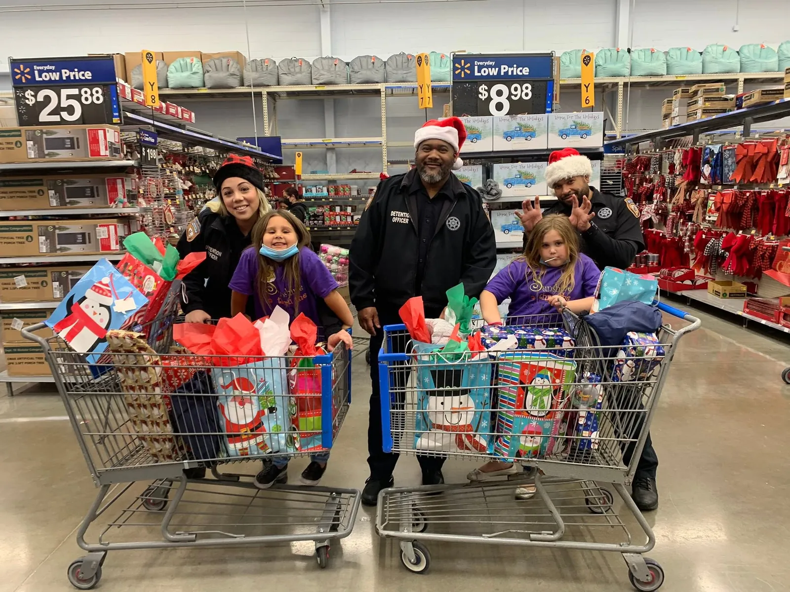 Children and officers with shopping carts full of holiday gifts at Sunshine Thru the Rain’s Shop With a Cop